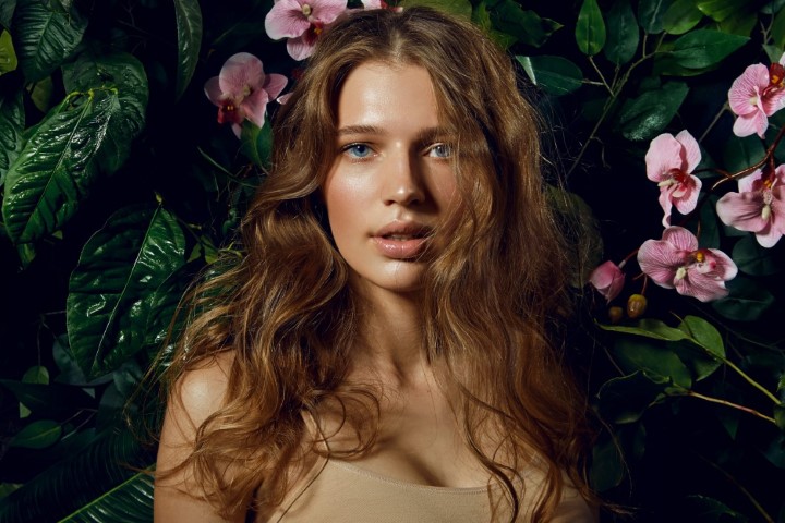 A,Beautiful,Blue-eyed,Long-haired,Brown-haired,Woman,Stands,On,A,Background